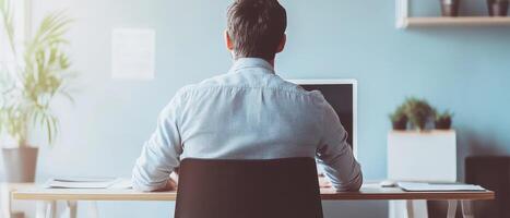 Man focused on work at a desk in a modern office photo