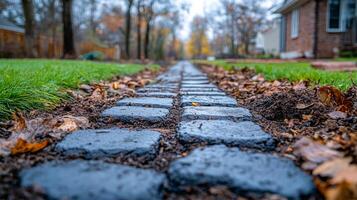 Cobblestone path through autumn leaves. A cobblestone path lined with fallen leaves leads through a serene neighborhood in the fall season. photo