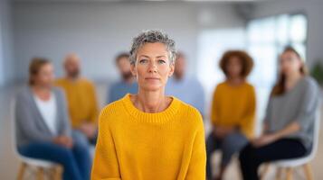 Confident woman in yellow sweater with support group in background photo