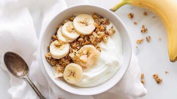 Yogurt with banana and granola photo