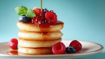 A stack of pancakes with syrup being poured on top photo