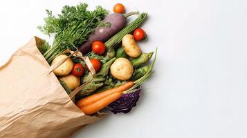 Fresh vegetables in paper bag on white background photo