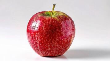 A red apple sitting on a white surface photo