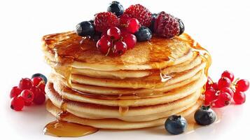 A stack of pancakes with berries and syrup photo