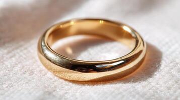A gold ring sitting on a white cloth photo