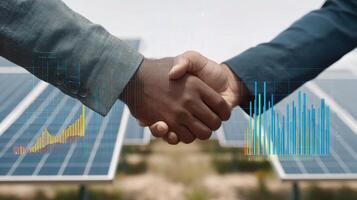 Two business people shaking hands in front of solar panels photo