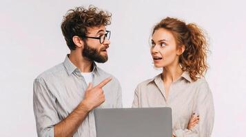 A man and woman are looking at a laptop photo