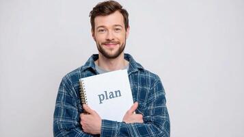 Man holding a notebook with plan written on it photo