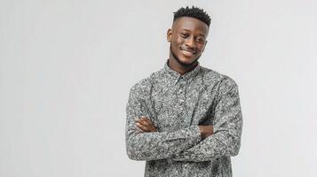 A young man with his arms crossed standing in front of a white background photo