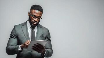 A man in a suit and glasses is using a tablet photo