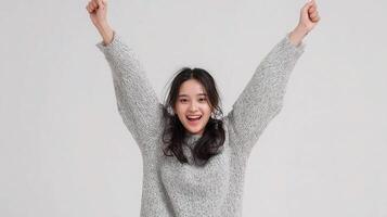 A woman in a sweater is raising her arms photo