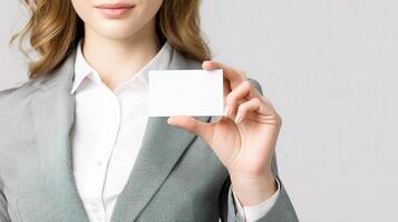 A woman in a business suit holding up a blank card photo