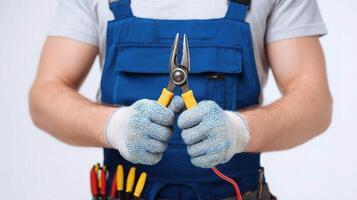 A man in overalls holding a pair of pliers photo