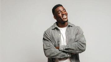 A man smiling while standing in front of a gray background photo