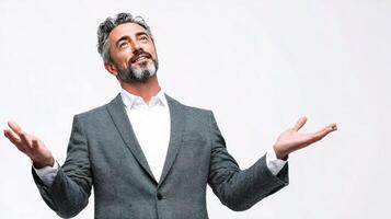 A man with a beard and suit is standing with his hands out photo