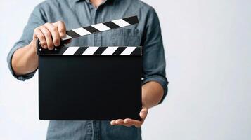 A man holding a black slate with a movie clapper board photo