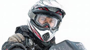 A man in a helmet and gear is riding a snowmobile photo