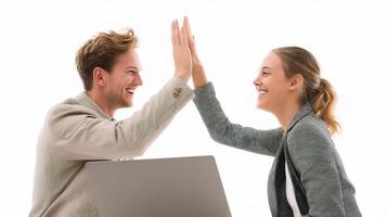 A man and woman high five each other while sitting at a desk photo