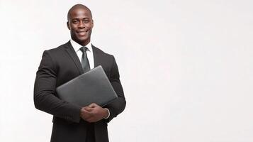A black man in a suit holding a laptop photo