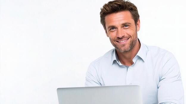 A man is smiling while using a laptop photo