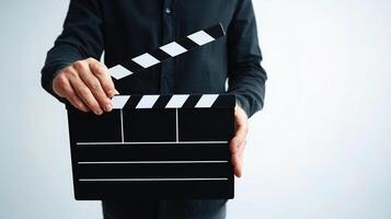 A person holding a clapper board with a black background photo