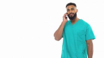 A man in a scrub suit talking on a cell phone photo