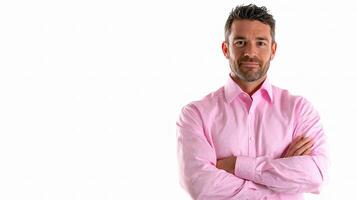 A man in a pink shirt standing with his arms crossed photo