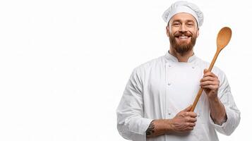 A man in a chef's uniform holding a wooden spoon photo