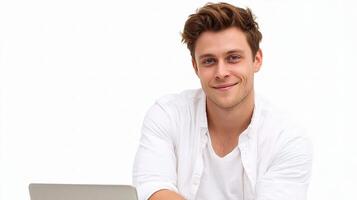 A man is smiling while sitting at a table with a laptop photo