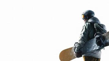 A snowboarder is standing in the snow holding his board photo