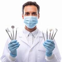 A man in a white coat and mask holding dental tools photo