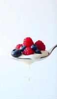 Yogurt with berries and blueberries on spoon photo