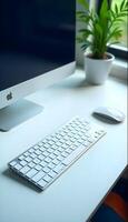 A white desk with a keyboard, mouse and computer photo