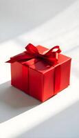 Caja de regalo roja con cinta sobre fondo blanco. foto
