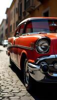 An old red car is parked on a cobblestone street photo
