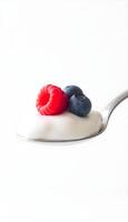 Yogurt with berries on spoon photo