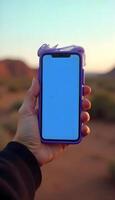 A person holding a purple iphone in the desert photo