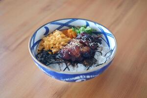 The bowl contains white steamed rice as the base, topped with various colorful ingredients photo