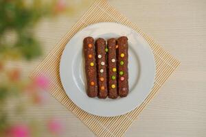 The bars appear rich and textured, likely containing nuts, oats, or crispy cereal inside the chocolate coating photo