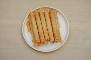 showcases a plate of crispy rolled wafer sticks photo