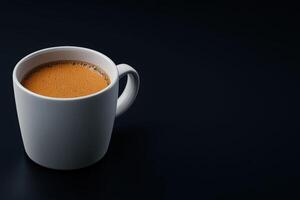 Delicious cup of coffee on a dark surface with foam on top at a cozy cafe photo