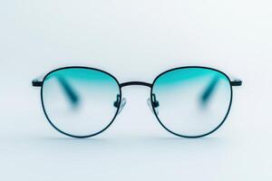 Stylish round glasses with teal-tinted lenses on a clean surface for modern eyewear appeal photo