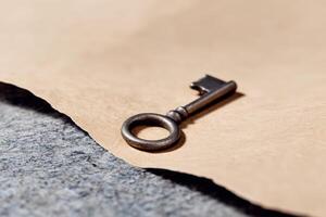 Vintage key resting on textured paper with a creative backdrop in modern lighting photo