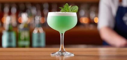 Fresh minty cocktail in coupe glass, vibrant green color, garnished with mint leaves, served at stylish bar photo