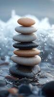 Zen stacked stones balance perfectly on the seashore as the ocean waves ripple around the tower. photo