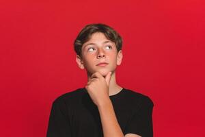 A boy is looking up at something on a red background photo