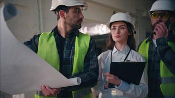 Busy Caucasian men builders woman inspector discussing blueprint in construction contractors architects technicians engineers talking walkie talkie workers foreman control building architectural draft video