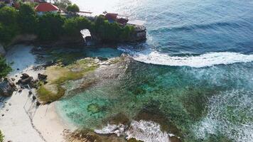 Coastline with cafe on rock and crashing waves on Nusa Ceningan island, Bali video