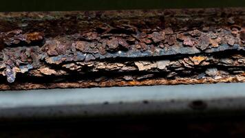 Heavily rusted and corroded metal surface. Layers of peeling. Reddish brown rust are prominent. indicating significant exposure to moisture and the elements. photo