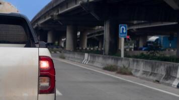 Rear side view of pickup car white color. A car slightly contaminated with mud. Stopped at a traffic light on the side of a concrete overpass. photo